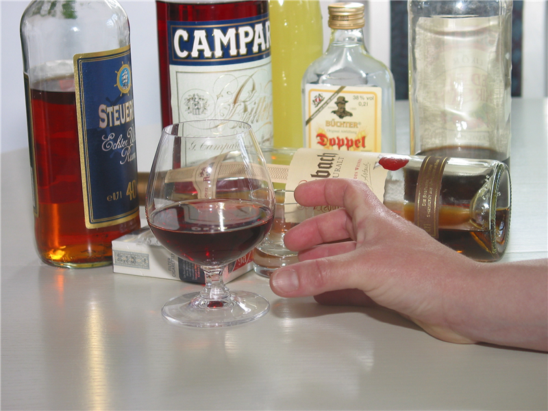 Eine Hand greift nach Alkoholflaschen
