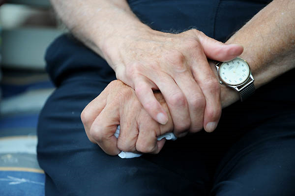 Zwei Hände - die eine hält ein Taschentuch, die andere liegt oben auf