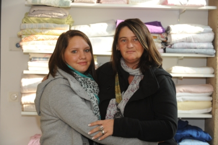 Zwei Frauen halten sich im Arm und scchauen freundlich in die Kamera