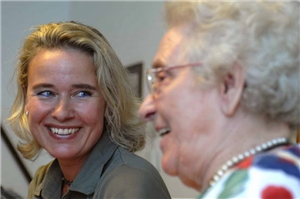 Eine junge Frau strahlt eine ätere Dame an