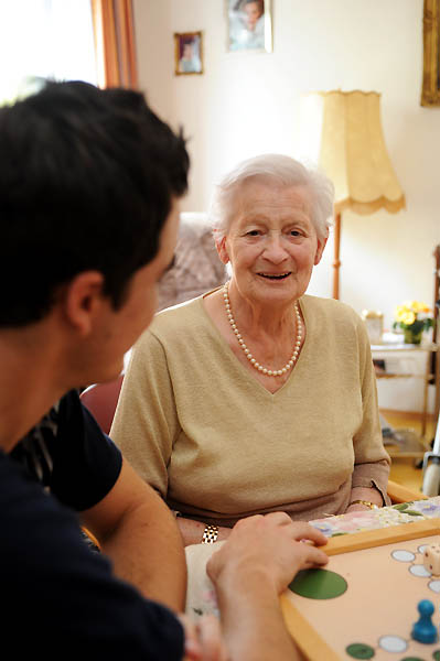 Ein junger, schwarzhaariger Mann unterhält sich mit einer älteren Dame